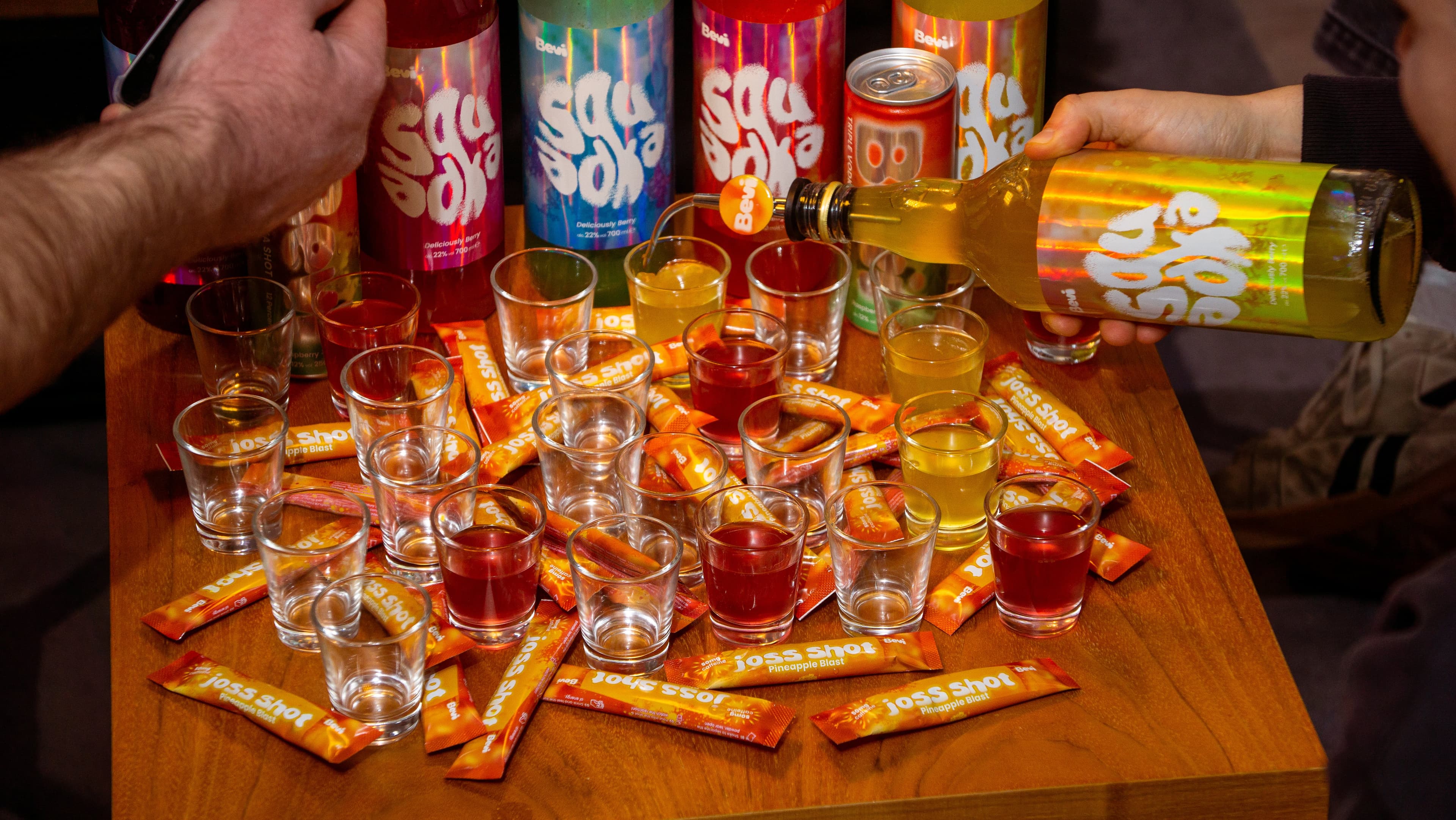 Colorful drinks and shot glasses on a wooden table